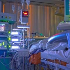 A photo of a hospital bed and medical equipment and monitors beside it. 